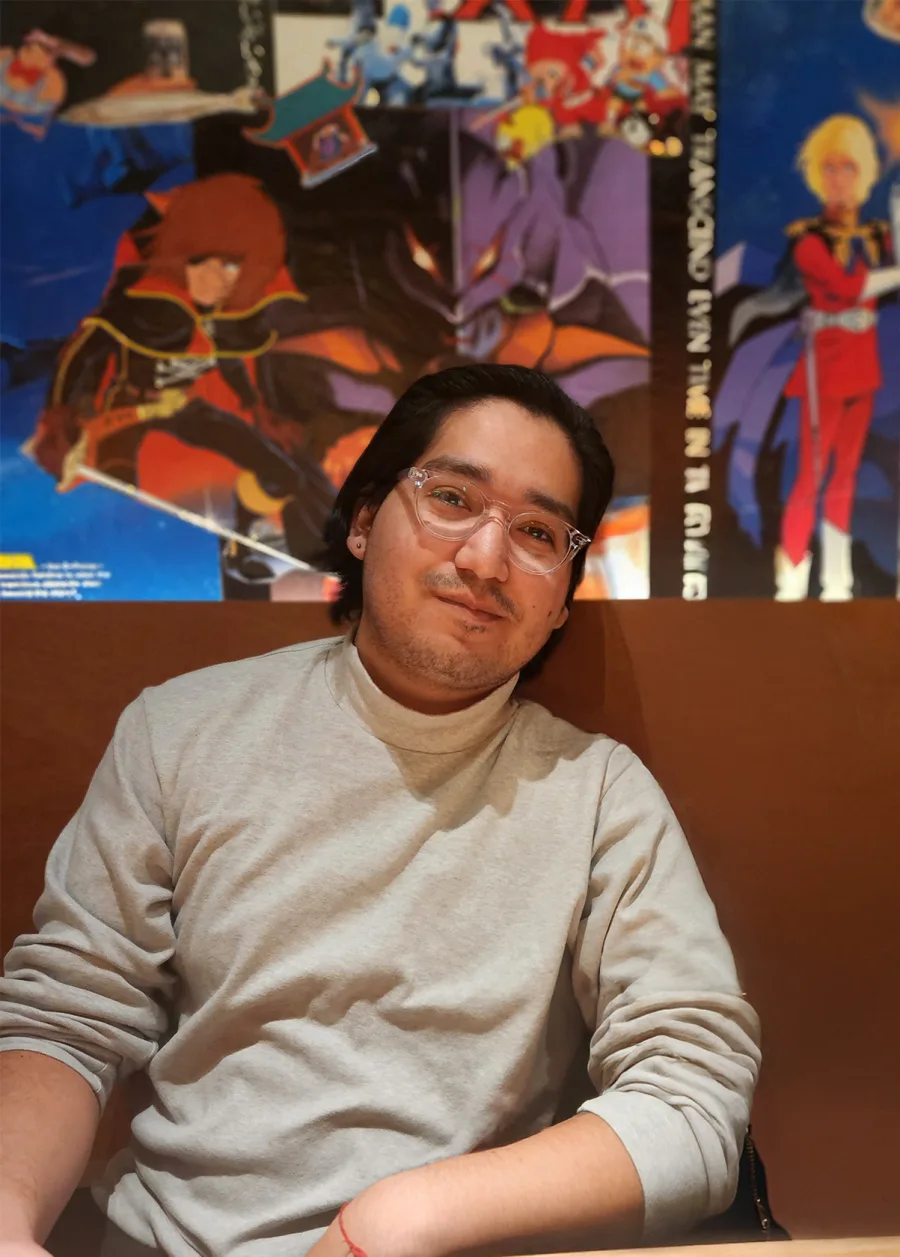 Eduardo Lopez in front of science-fiction and animation artwork